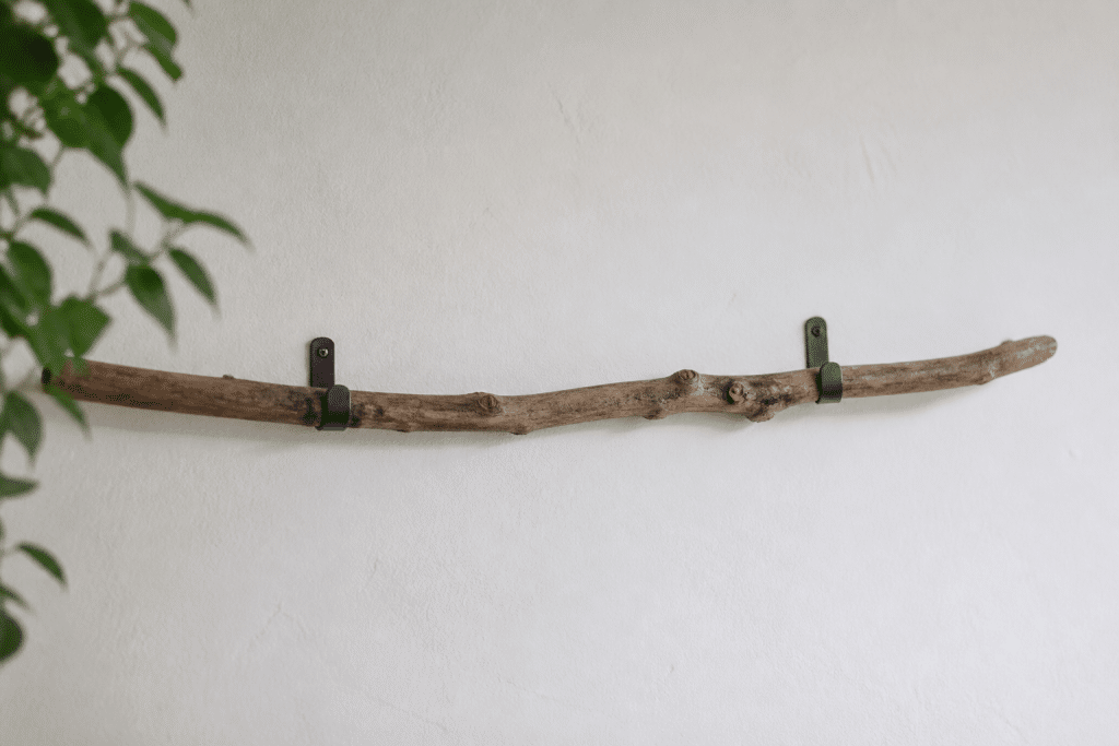 Branche bois naturelle fixée mur avec crochets metalliques