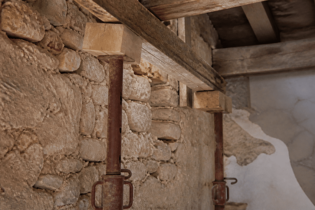 Etais metalliques et madriers soutenant mur construction