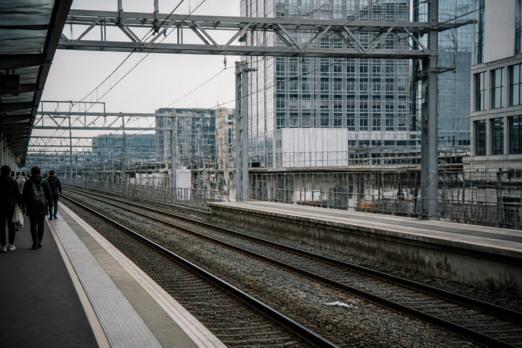 Gare ferroviaire avec voyageurs et batiments urbains