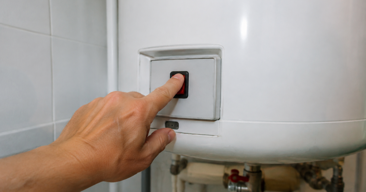 Doigt enfonce bouton marche forcee chauffe-eau