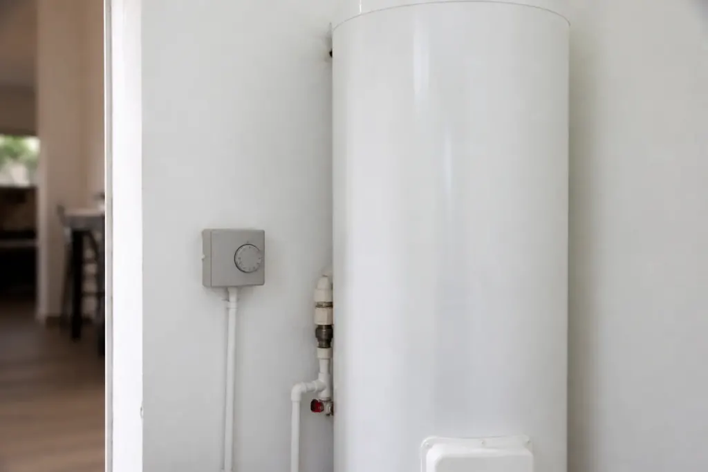 Chauffe-eau cylindrique blanc et petit boitier gris avec minuterie