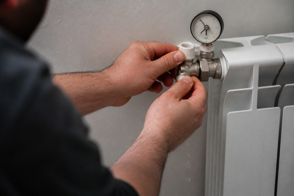 Eau s'echappant d'une purge radiateur avec manometre visible