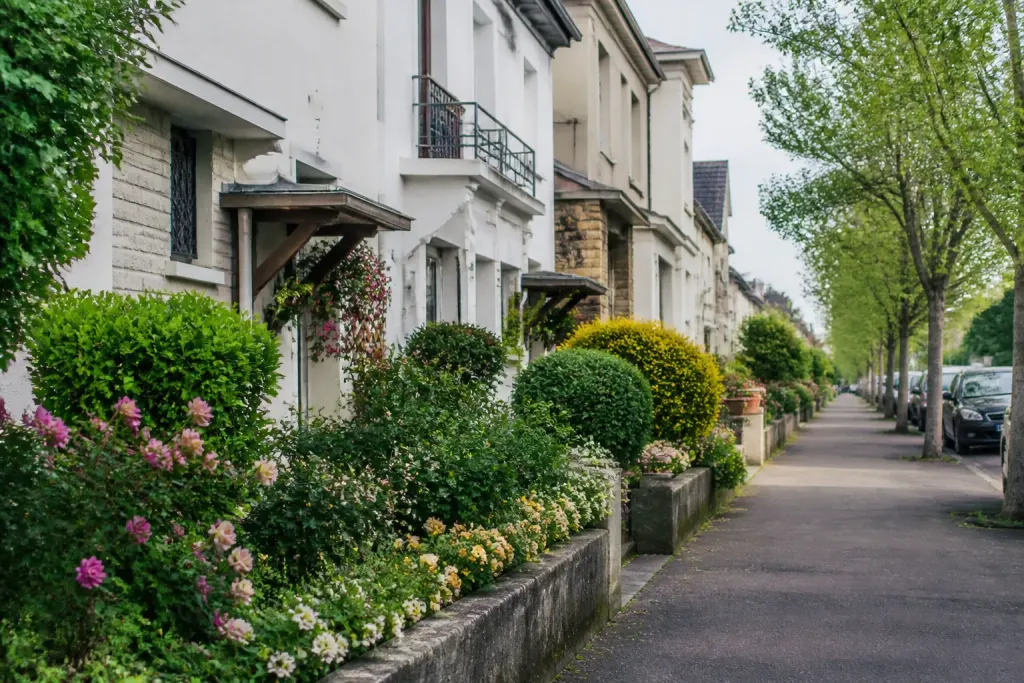 Rue residentielle avec maisons et jardins fleuris au printemps